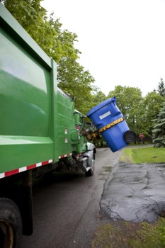Worker loading commercial waste into a van at a dockside office